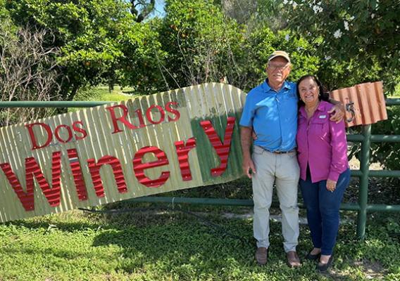 Two people standing in front of Dos Rios Winery sign